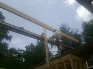 Carpenter setting a ridge beam over a new addition frame — Ice Dam Removal by Roofing Brothers in Meeker